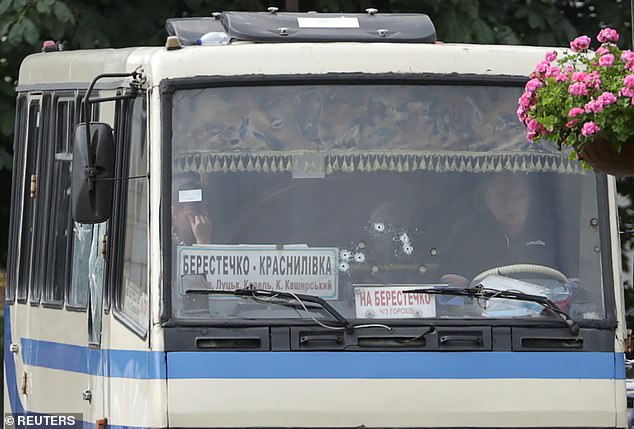 Hostages are seen through a windscreen damaged by gunshots, after the passenger bus was seized