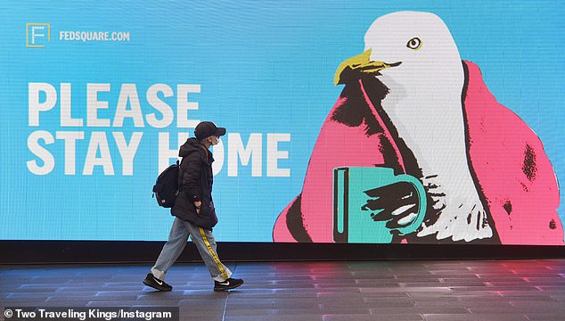 The authors said containment strategies for COVID-19 required people to work from home and this imposes a productivity loss. Pictured: Woman walks passed sign urging people to stay home in Melbourne