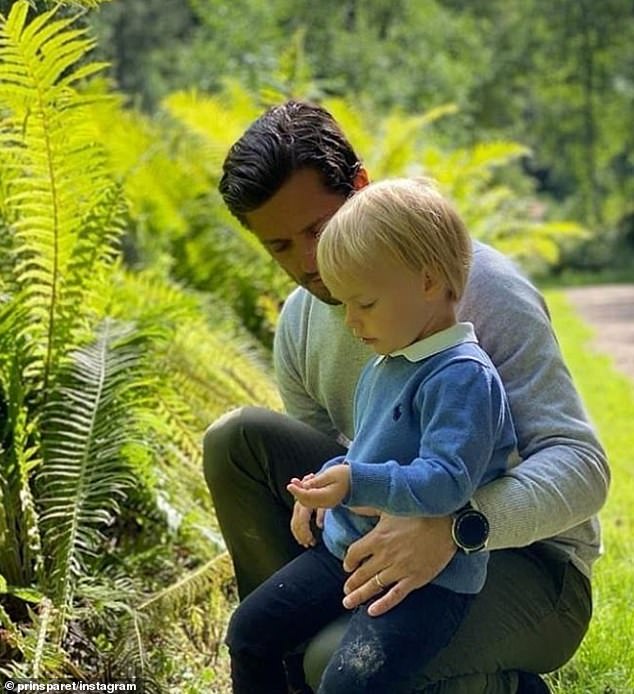 The young royal (seen with his father) sported an adorable outfit - a blue jumper over a white shirt - for the special occasion on Thursday