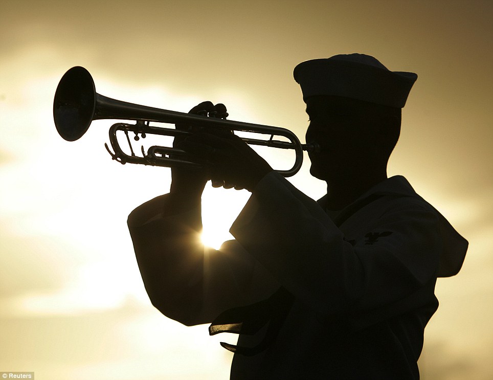 Tribute: A U.S. Navy sailor plays taps for Pearl Harbor survivor Lou Soucy, whose remains were being interned on the USS Utah, during a memorial ceremony on Ford Island in Honolulu, Hawaii, on Tuesday