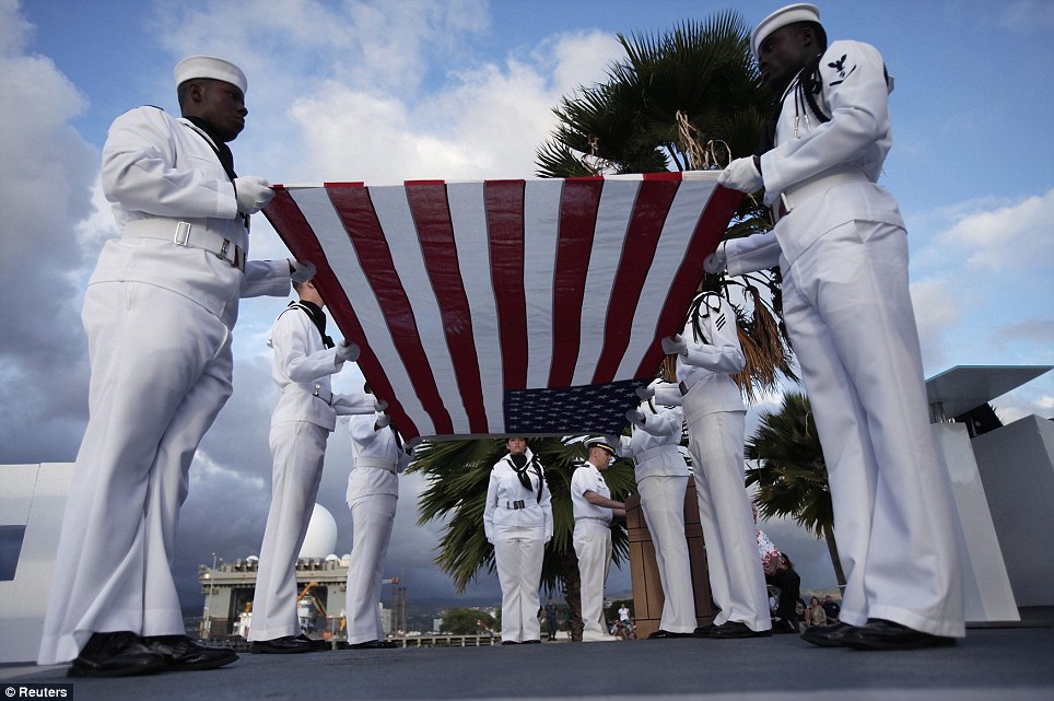Remembered: U.S. Navy sailors perform a flag ceremony for Pearl Harbor survivor Lou Soucy, whose remains were being interned on the USS Utah, during a memorial on Ford Island in Honolulu, Hawaii, on Tuesday