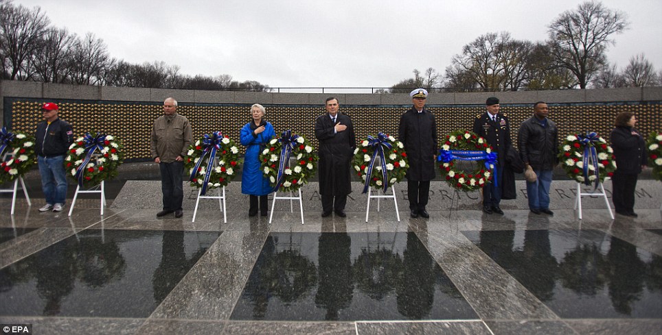 Respectful: Though official commemorations were cancelled due to heavy rain, a group of visitors to the World War Two Memorial improvised a wreath-laying ceremony to commemorate Pearl Harbor Day in Washington D.C.