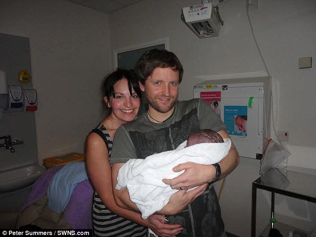 Delighted new parents Susan and Mike Hughes hold their son in hospital just moments after he was born