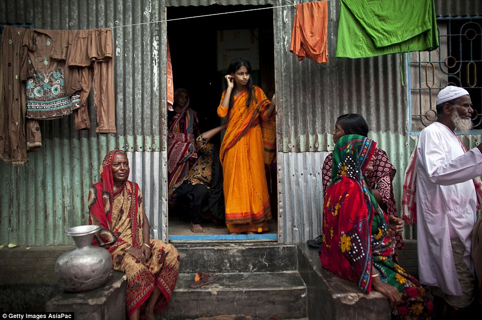 Apprehensive: Nasoin Akhter stands in the doorway of a neighbour