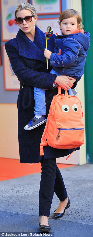Balancing act: The mother-of-three expertly balanced her son while holding on to his orange backpack