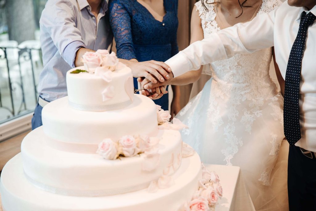 Молодожены разрезают свадебный торт
